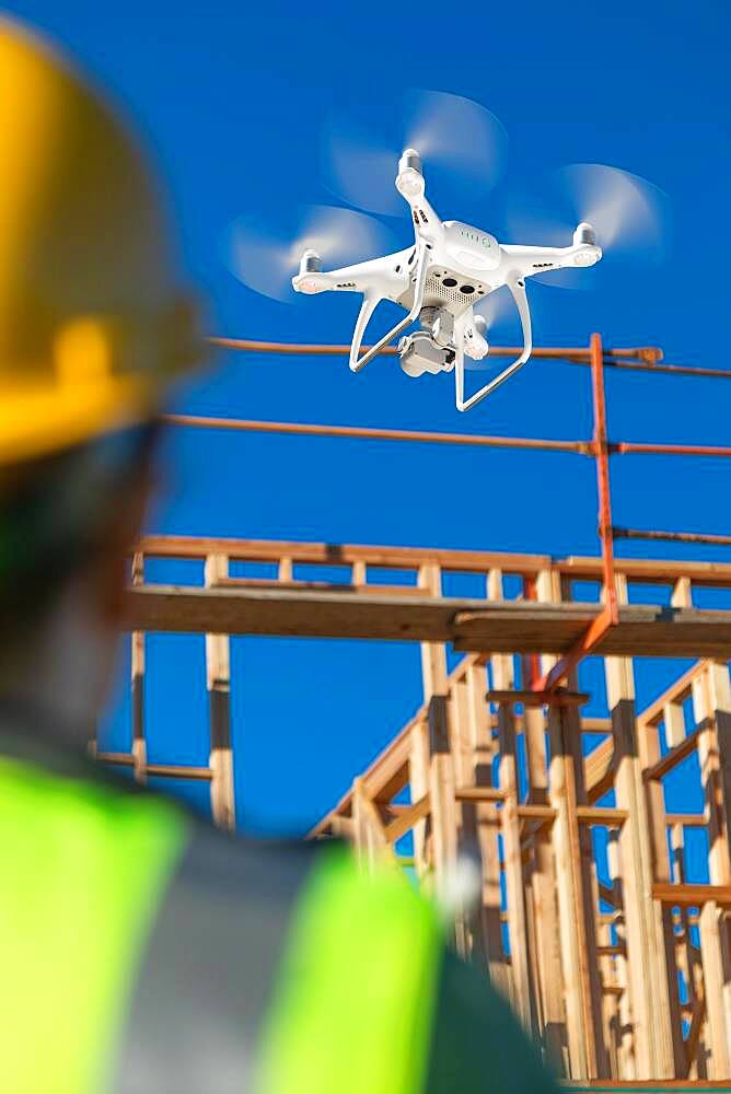 Female pilot flies drone quadcopter inspecting construction site