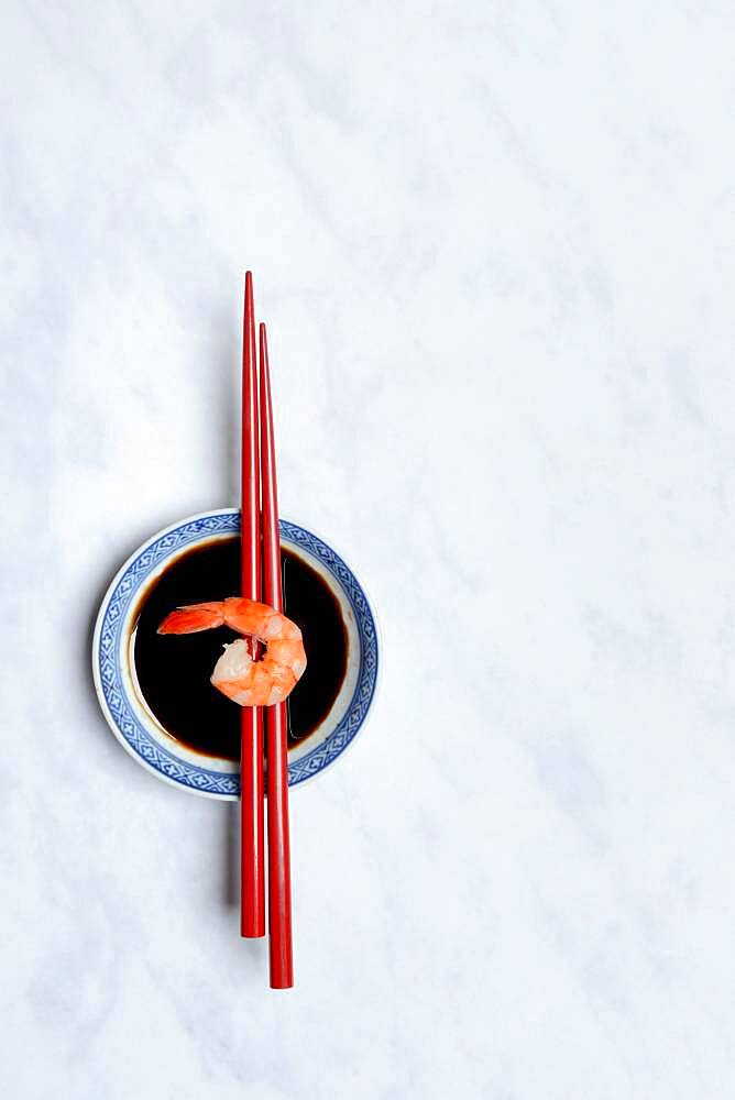 Cooked shrimp on chopsticks and shell with soy sauce, Germany, Europe