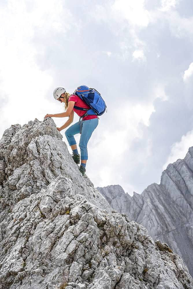 Young female hiker with helmet, rocky mountains and scree, hiking to the Hochkalter, Berchtesgadener Alpen, Berchtesgadener Land, Upper Bavaria, Bavaria, Germany, Europe