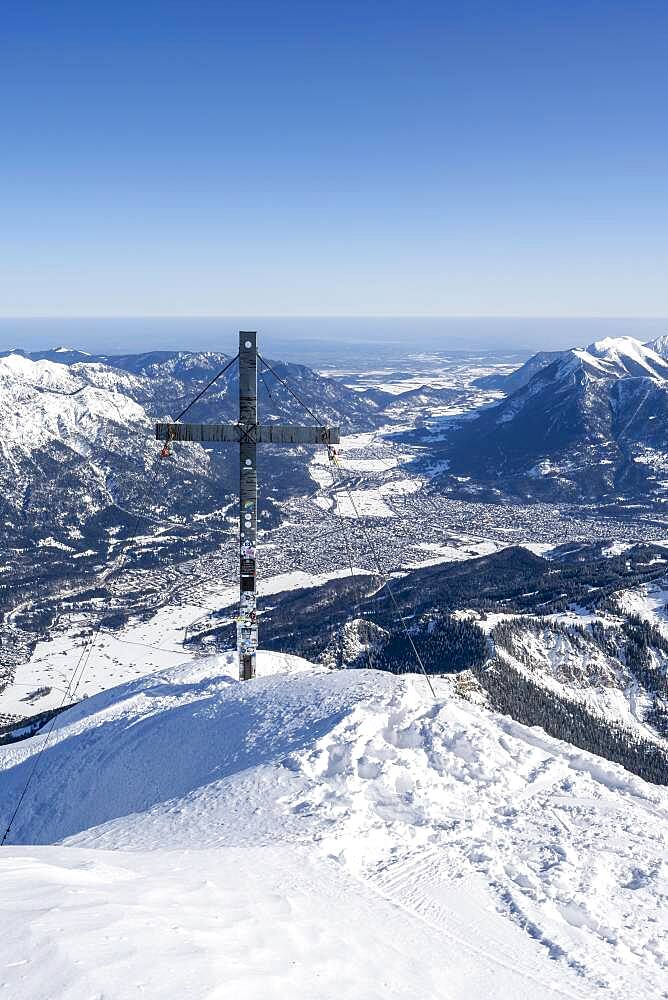 Alpspitz summit with summit cross, ski tour to the Alpspitze, view to Garmisch-Patenkirchen, Wetterstein mountains with snow in winter, Garmisch-Partenkirchen, Bavaria, Germany, Europe