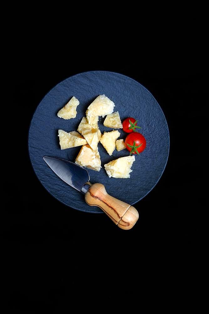 Cheese knife and cut Parmesan cheese on plate, Germany, Europe