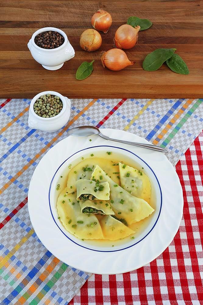 Swabian cuisine, Maultaschen in broth with chives, soup plate, spoon, green and black pepper, Germany, Europe