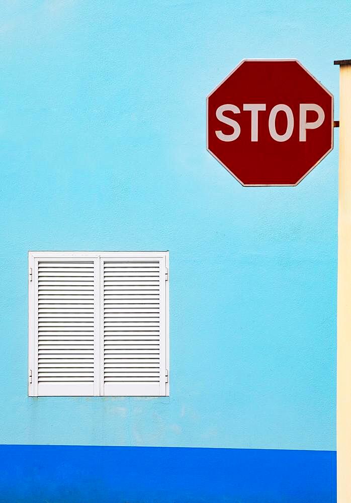 Light blue house facade with closed white shutters and stop sign, Porto Formoso, Sao Miguel Island, Azores, Portugal, Europe