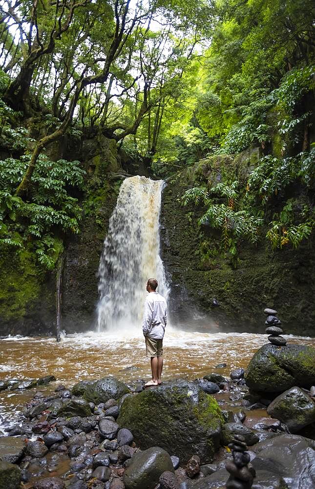 Hiker standing by the Salto do Prego waterfall, Faial da Terra, Sao Miguel, Azores, Portugal, Europe