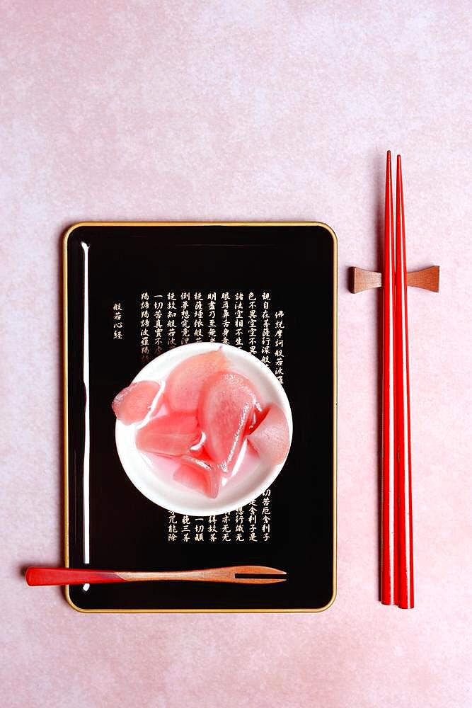 Pickled ginger slices in bowl and chopsticks, ginger