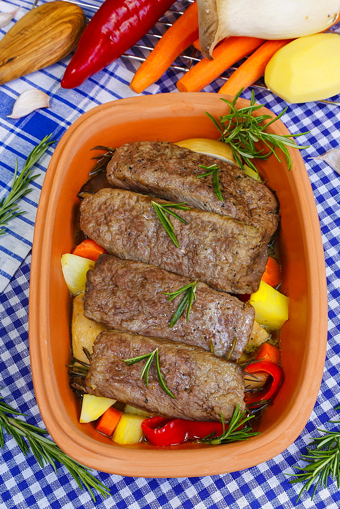 Southern German cuisine, lamb on vegetables from the Roman pot, rosemary, carrots, red peppers, potato, clove of garlic, Germany, Europe