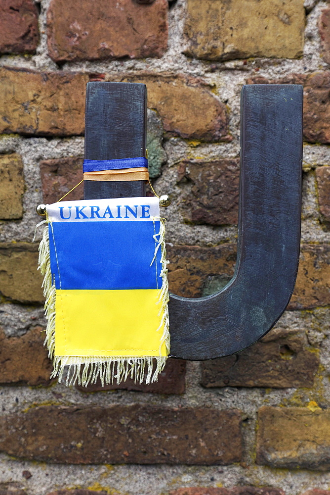 Flag in the national colours of Ukraine hanging from the letter U of Russia, in memory of the Ukrainian concentration camp victims, Wall of Nations, Ravensbrueck Memorial, former woman's concentration camp, Fuerstenberg Havel, Brandenburg, Germany, Europe