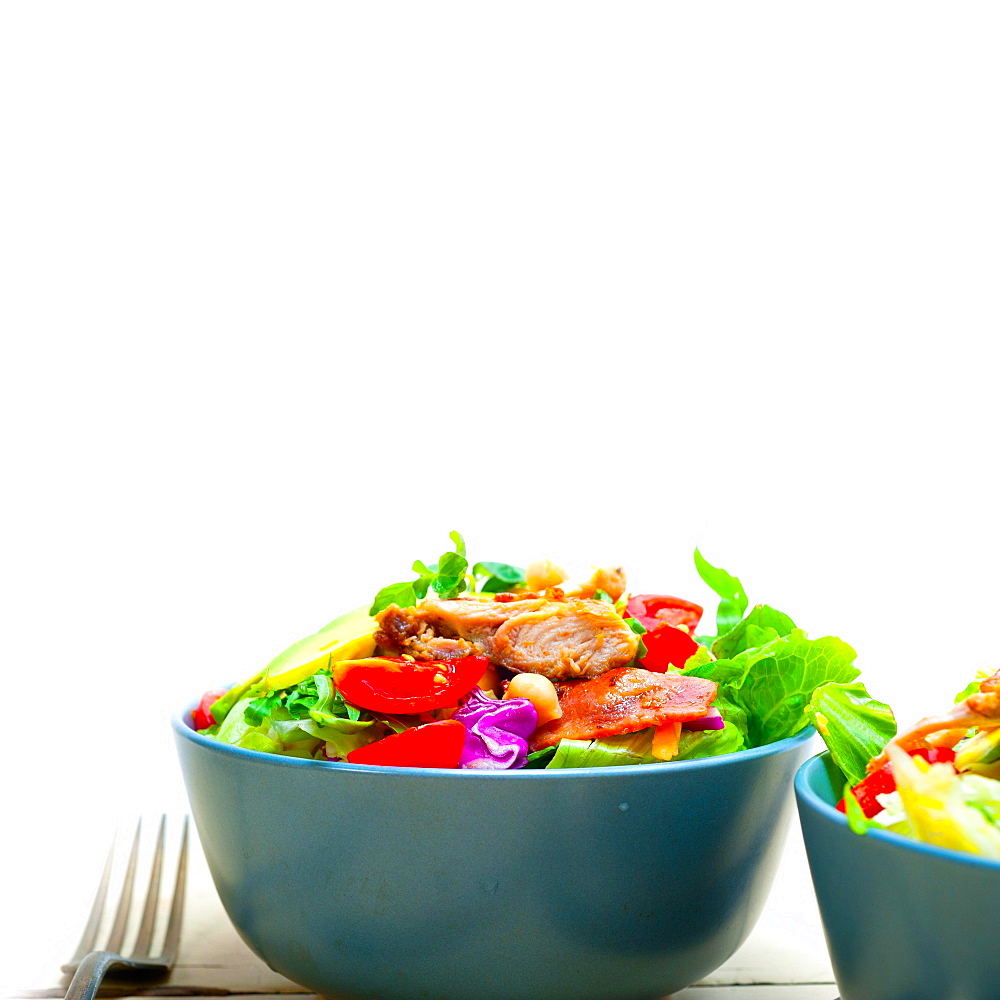 Fresh and healthy Chicken Avocado salad over rustic wood table