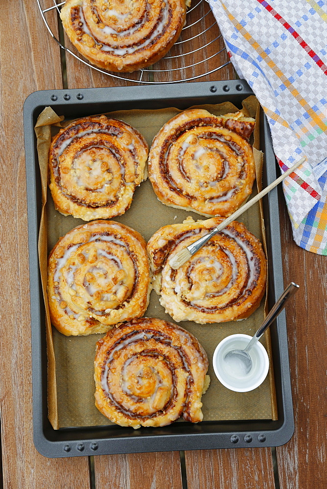 Swabian cuisine, baking, cinnamon roll on baking tray, brush to brush with icing, sweet yeast pastry with nuts, crumbles and icing, Danish pastry, sweet pastry, Germany, Europe