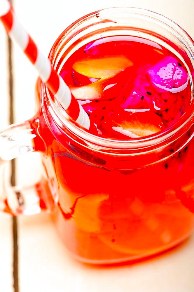 Fresh fruit punch refreshing summer drink over white rustic wood table