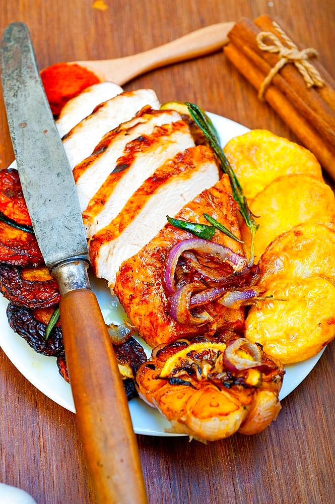 Roasted grilled BBQ chicken breast with herbs and spices rustic style