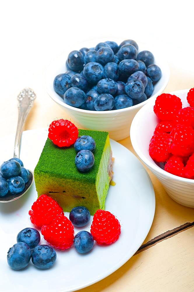 Green tea matcha mousse cake with raspberries and blueberries on top