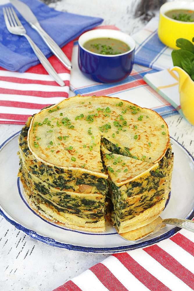 Swabian cuisine, spinach cake spoon style with pancakes, Flaedle layered, pancake cake on plate, Swabian speciality, herb sauce in the back, sauce, knife, fork, Germany, Europe