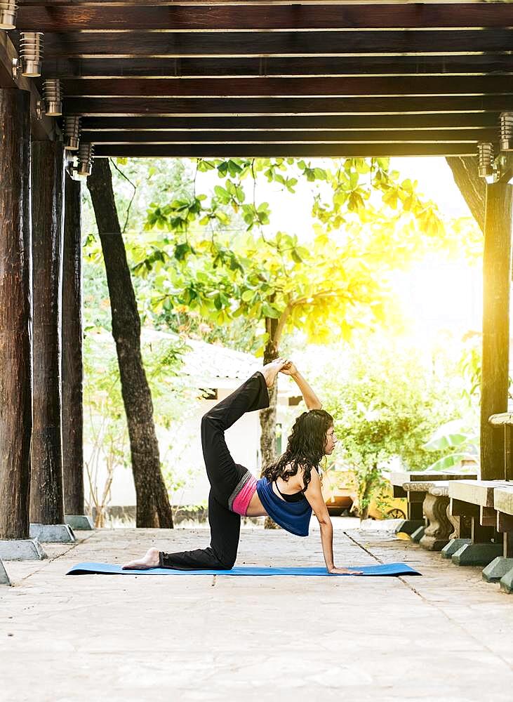 Woman doing quadriceps yoga outdoors, girl doing yoga and quadricep stretching fitness