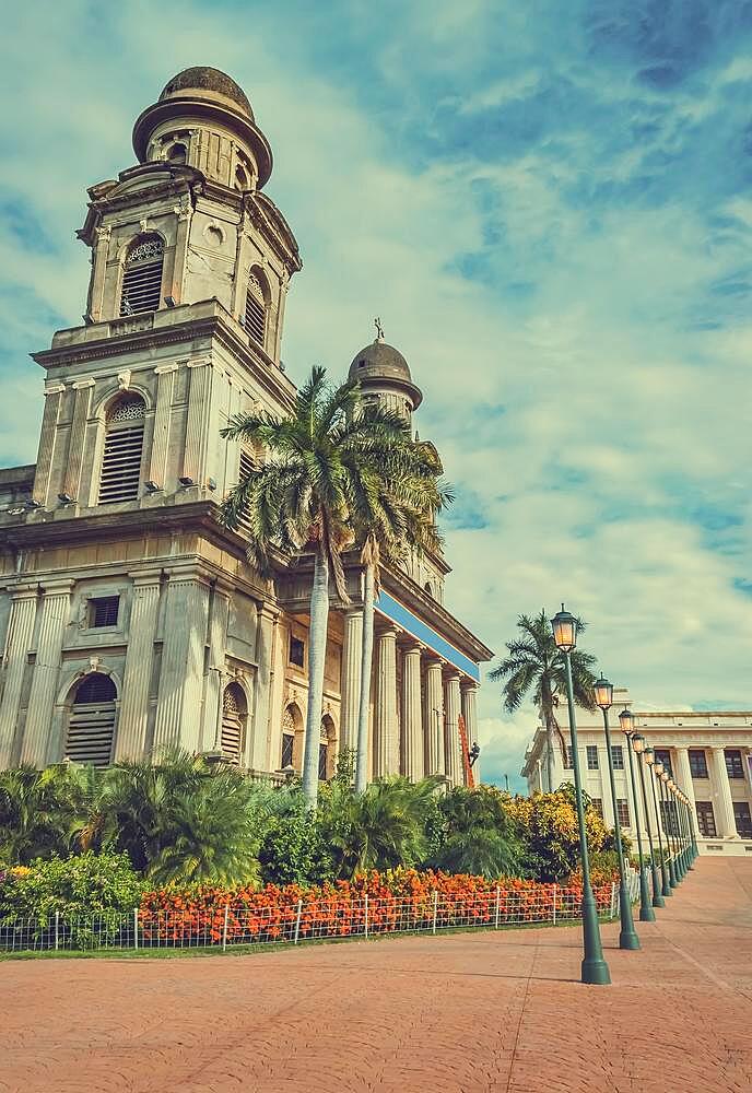 Old cathedral of managua with blue sky, close up of an old cathedral next to lanterns around