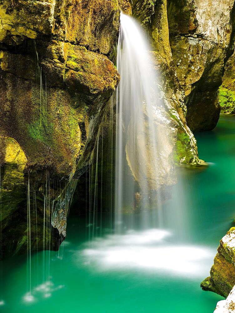 Waterfall plunges into the emerald green Soca River, Soca Valley, Triglav National Park, Bovec, Slovenia, Europe