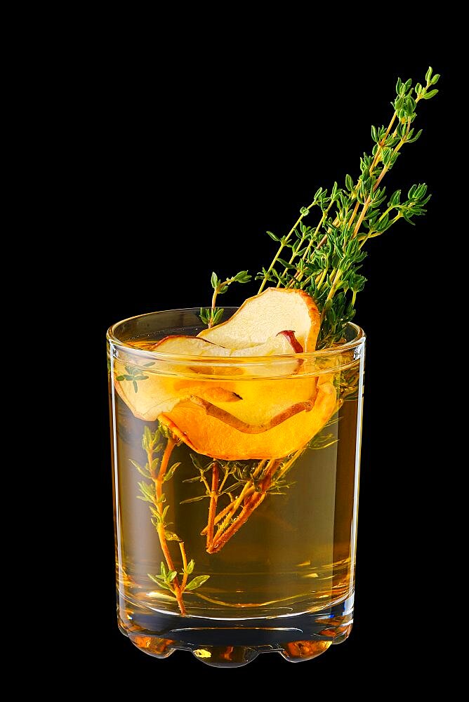 Hot apple winter drink with thyme and ginger isolated on black