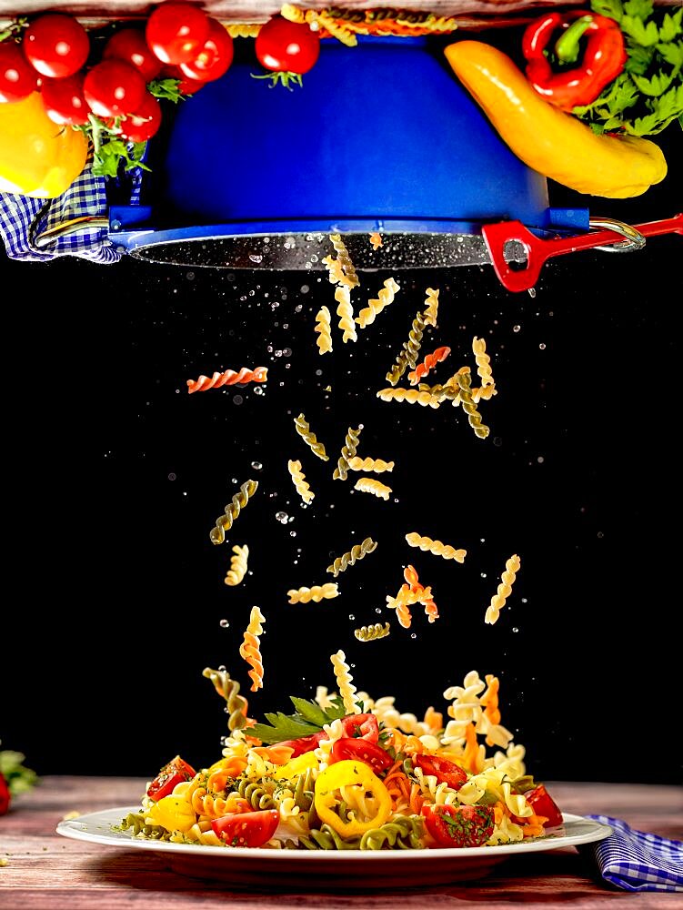 Food photography, Colourful noodles fall from a pot onto a plate, Vegetarian