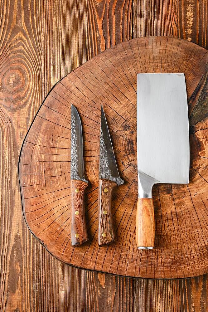 Top view of cleaver and knives on wooden stump