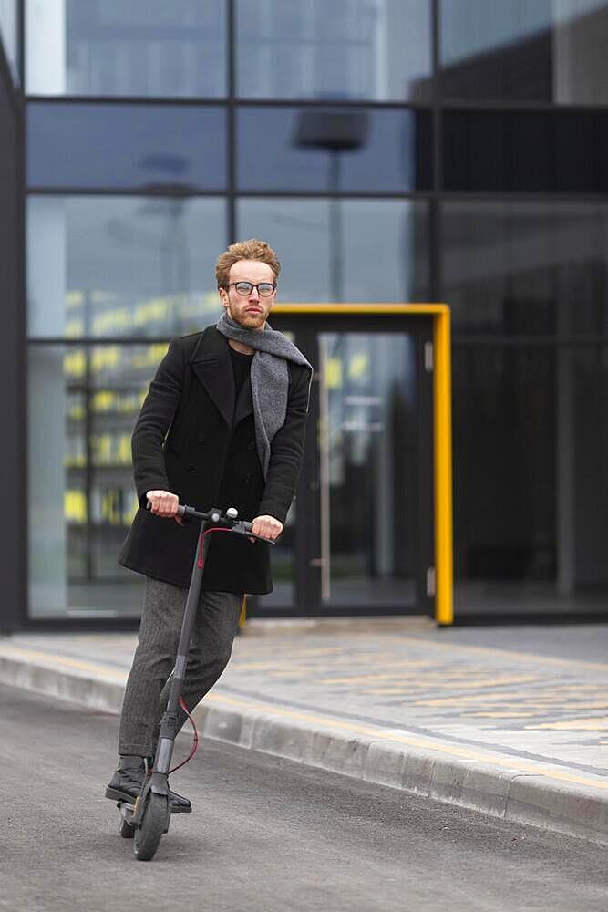 casual male posing with electric scooter