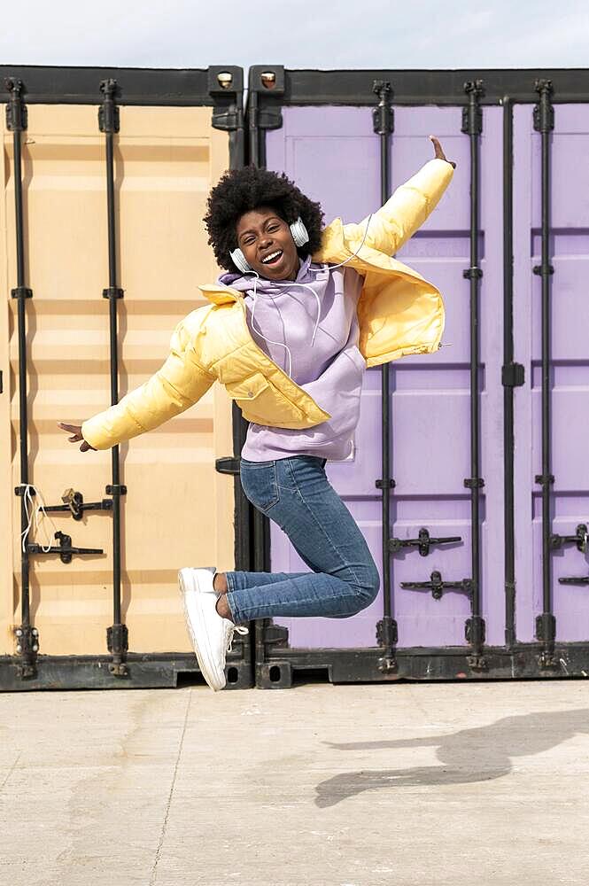 Portrait young woman with headphones jumping9