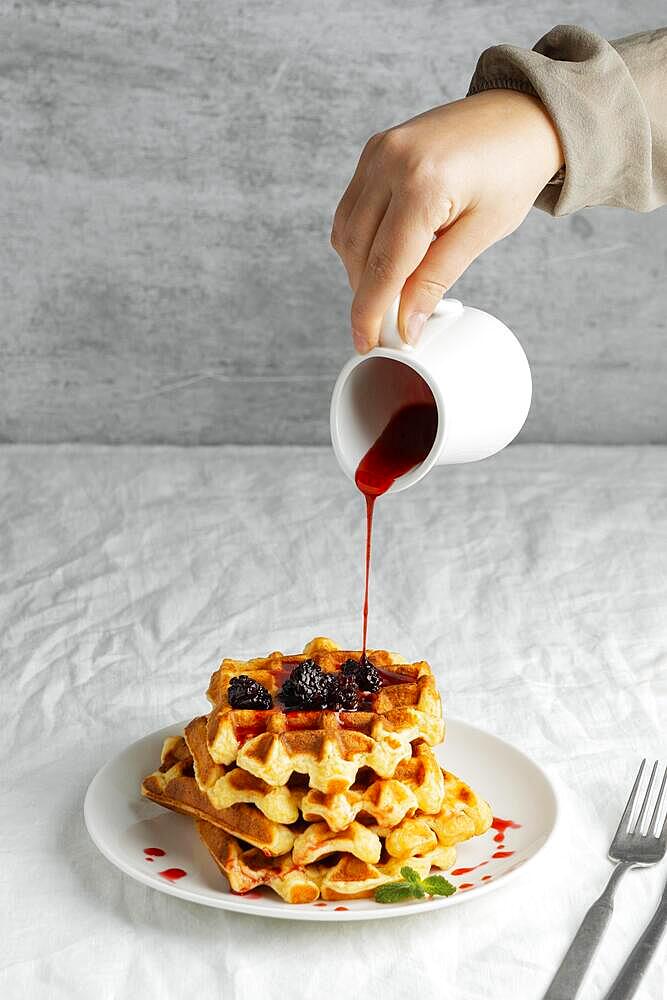 Close up hand pouring syrup