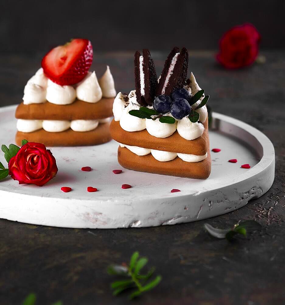 Sponge cakes, a heart-shaped cakes with cream and fruit. Dessert on Valentine's Day