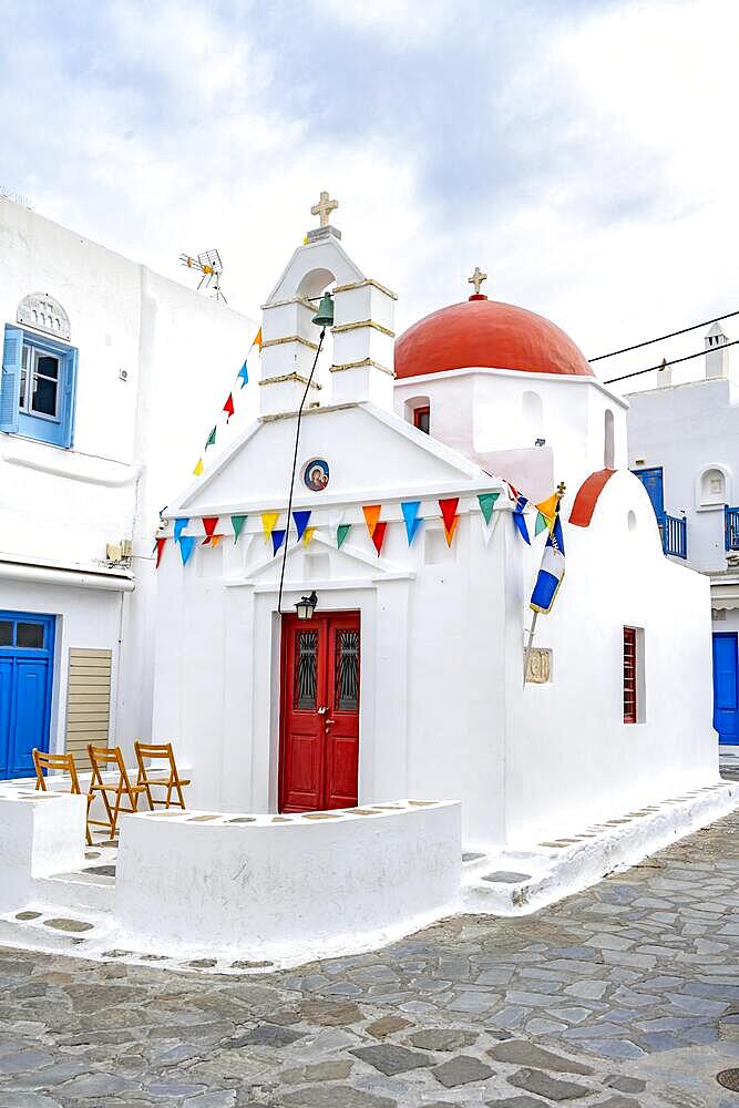 White Cycladic Greek Orthodox Church decorated with flags, alleys of the old town Chora, Mykonos Town, Mykonos, Cyclades, Greece, Europe