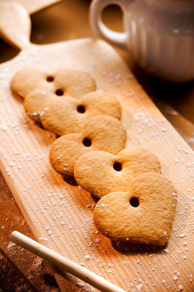 Baking biscuits, board with biscuits in kitchen