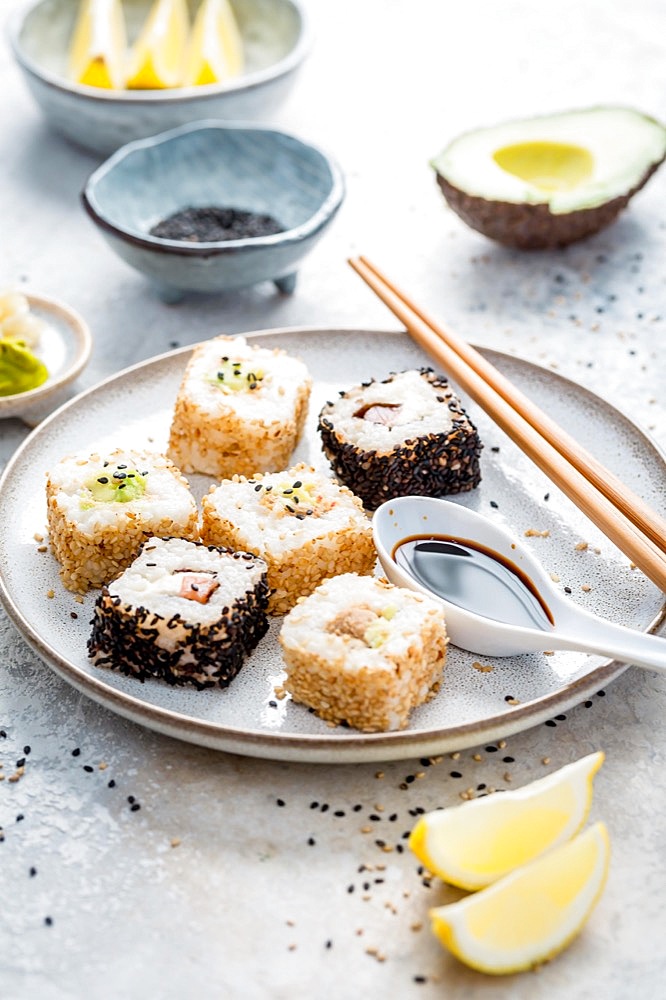 Tuna and avocado sushi wrapped in sesame seeds with ingredients