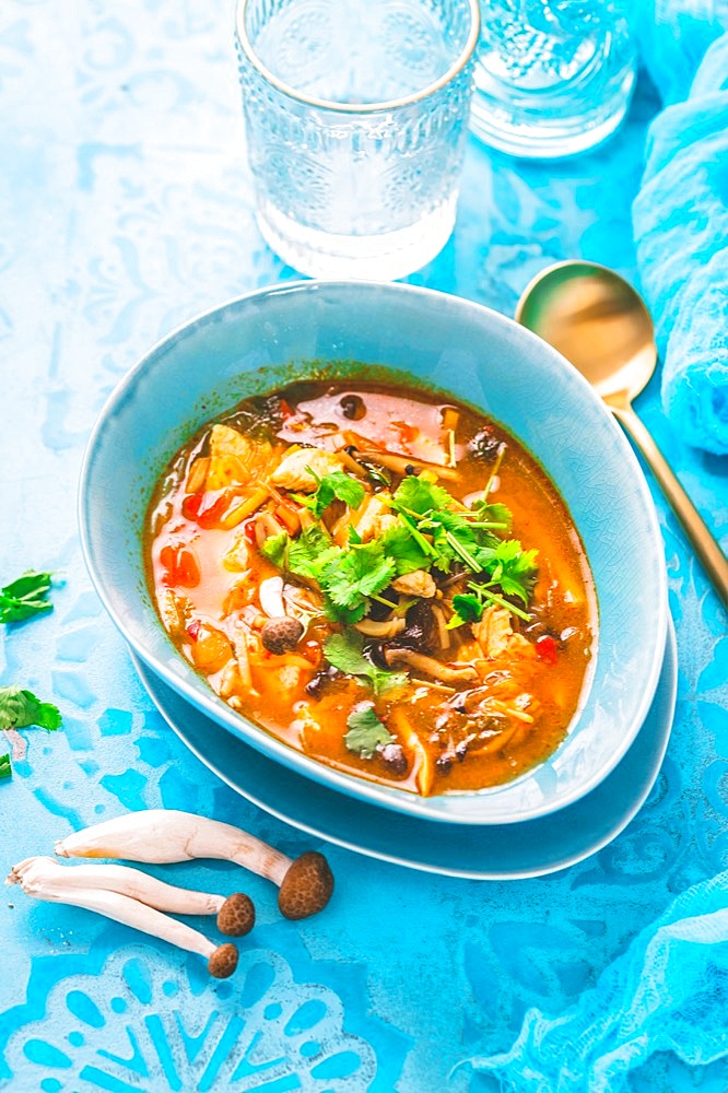 Thai chicken red curry. Thailand tradition red curry soup with chicken, mushrooms and coconut milk on blue background