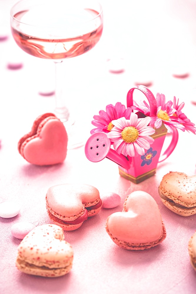 Happy Mothers Day - sweet macarons and glass of rose sparkling wine with flowers in pink tone