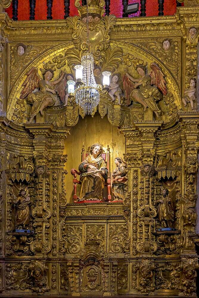 Interior of a baroque church decorated with images of saints and walls with gold leaf ornaments in the historic city of Ouro Preto, Minas Gerais, Brasil