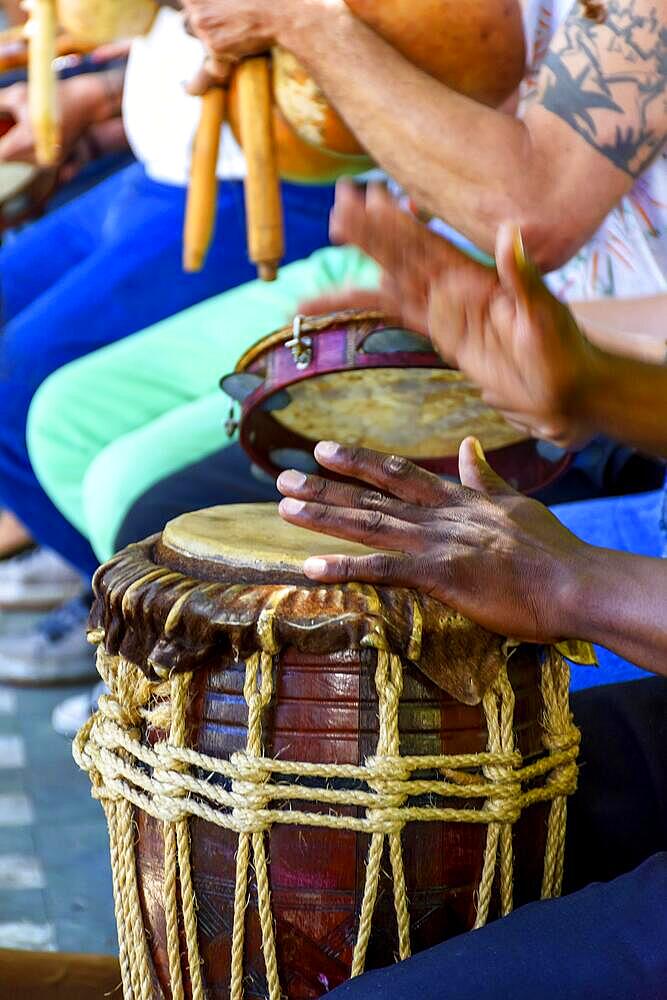 Percussionist playing a rustic and rudimentary percursion instrument atabaque during afro-brazilian cultural manifestation, Brasil