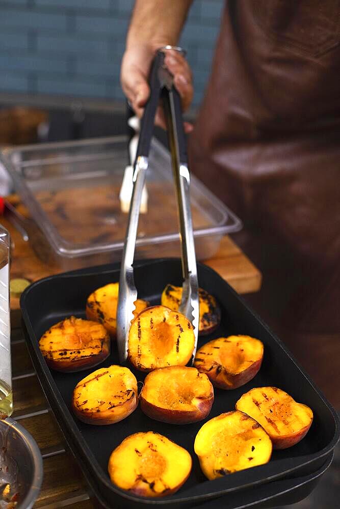 Grill with tasty cut peaches and flame, closeup. Delicious food, dessert. Outdoors party