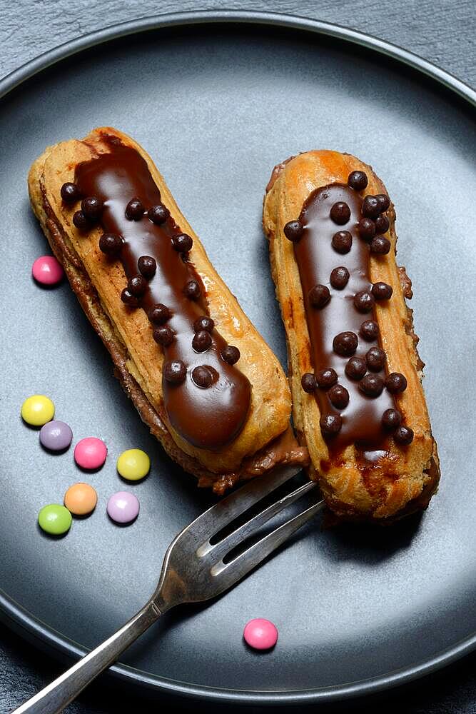 Two chocolate eclairs on a plate, eclair