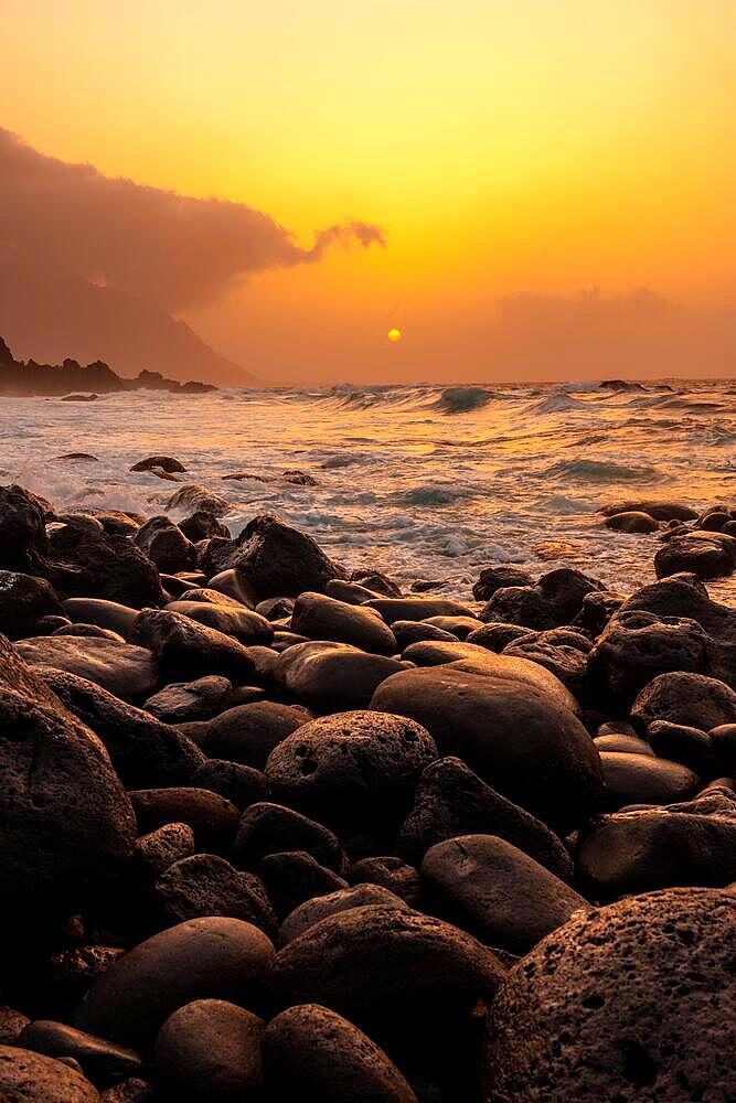 El Hierro Island. Canary Islands, landscape of stones next to Charco azul in spring orange sunset, vertical photo