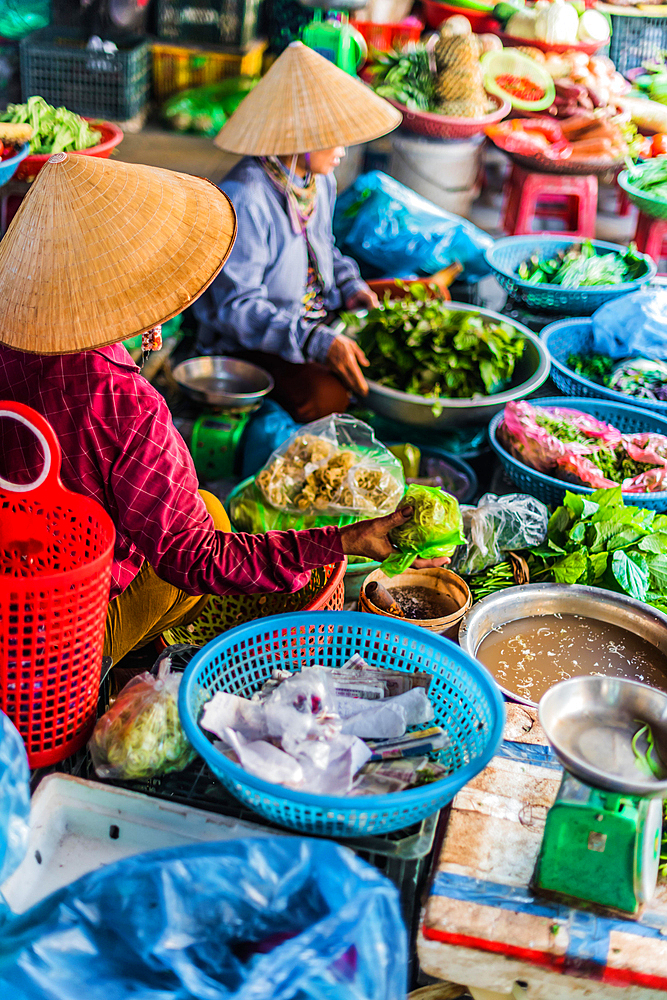 Women selling food on the street of Hoi An in Quang Nam Province, Vietnam, Asia