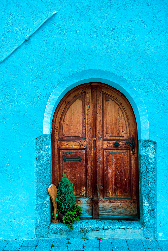 Old reddish brown wooden door on blue wall