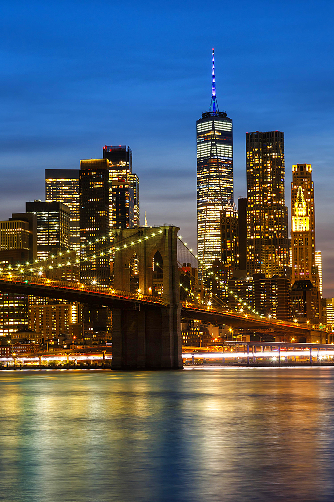 New York City skyline of Manhattan with Brooklyn Bridge and World Trade Center skyscraper at night in New York, USA, North America