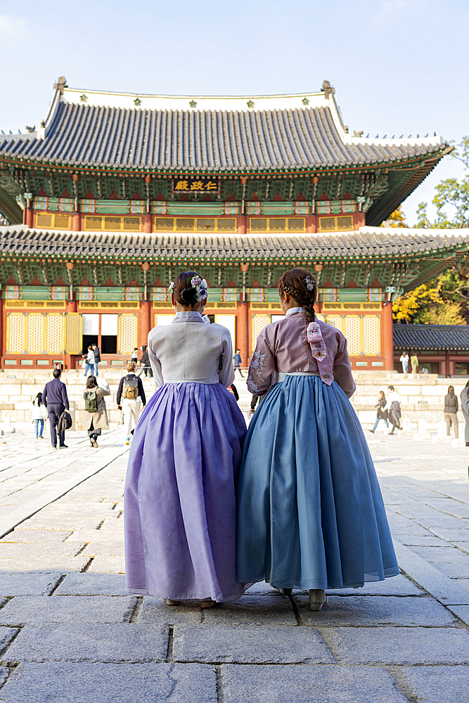 Young woman in traditional hanbok in front of the audience hall Injeongjeon Hall, with tourists, Changdeokgung Palace, Jongno-gu, Seoul