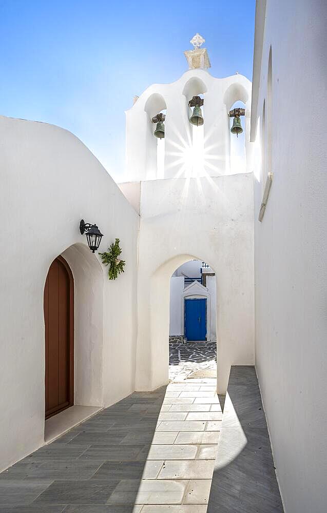 Archway with bells of the Greek Orthodox Chapel of Agios Antonios, with sun star, alleys of the village of Marpissa, Paros, Cyclades, Greece, Europe