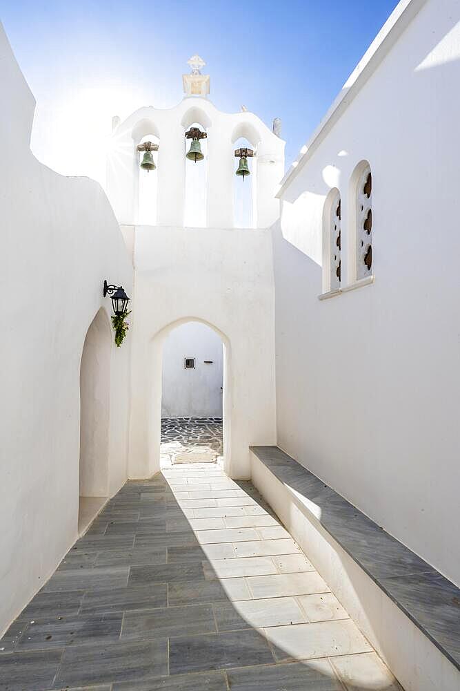 Archway with bells of the Greek Orthodox Chapel of Agios Antonios, with sun star, alleys of the village of Marpissa, Paros, Cyclades, Greece, Europe