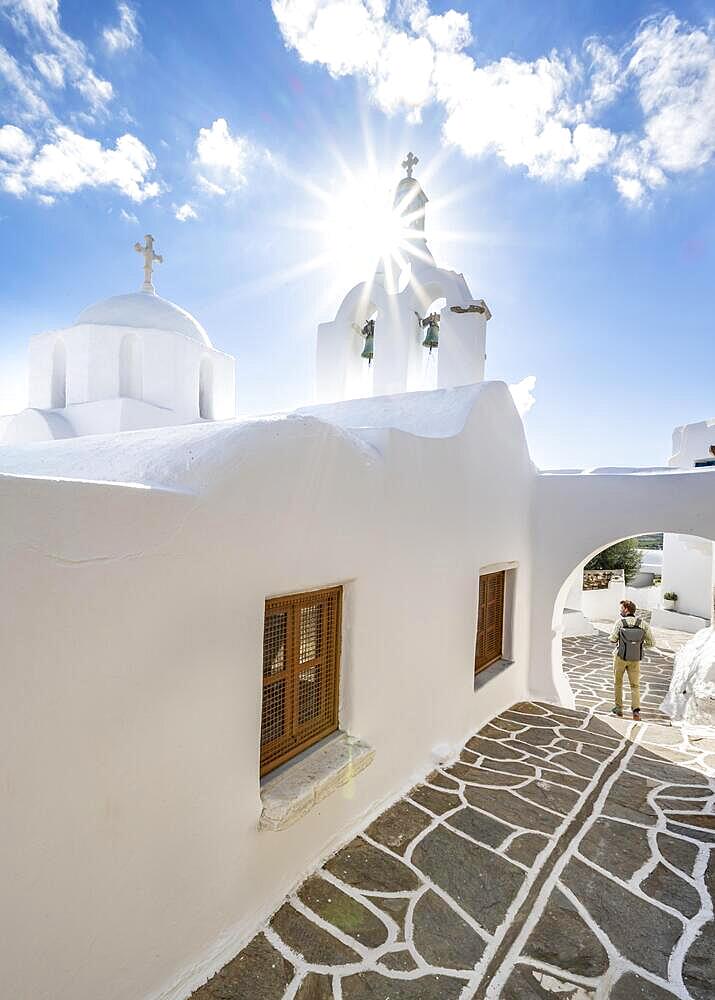 White Greek Orthodox Church with Star of the Sun, young man in the picturesque alleys of the village of Marpissa, Paros, Cyclades, Greece, Europe