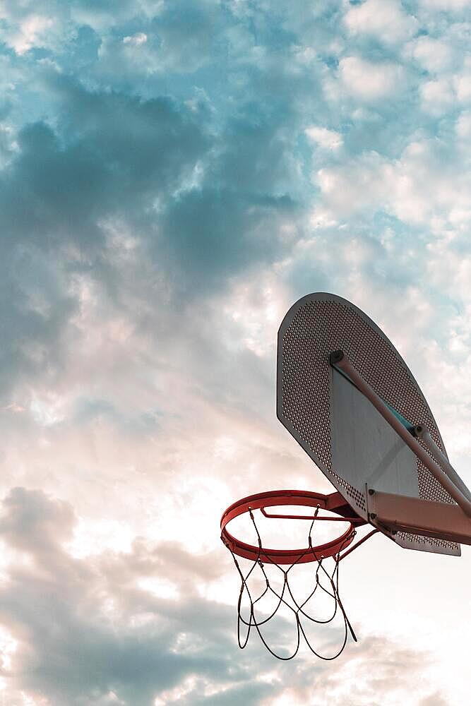 Low angle view basketball hoop against cloudy sky