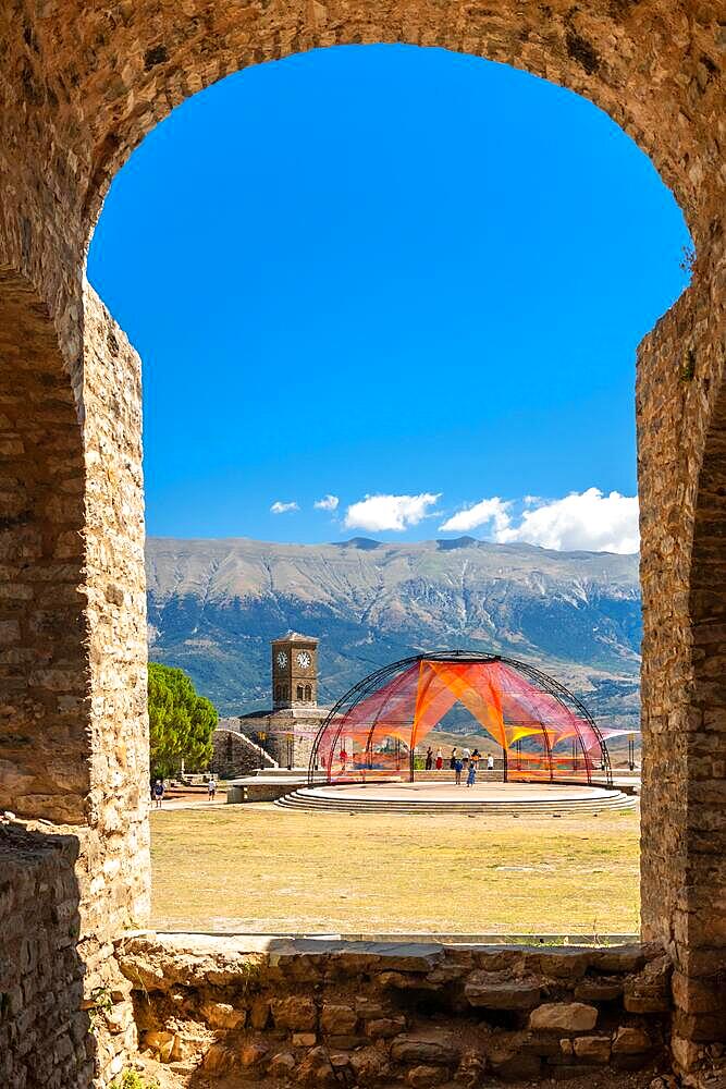 Arches of the fortress of the Ottoman castle of Gjirokaster or Gjirokastra and in the background the church with the clock tower. Albania, Kulla e Sahatit