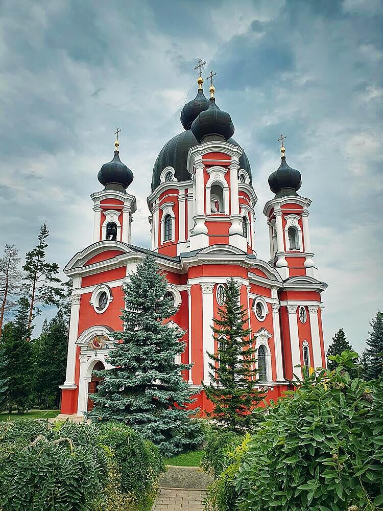 Curchi Monastery outdoor view of the famous landmark in Orhei, Moldova. Christian Orthodox style church tradional for eastern Europe culture. Beautiful garden with trees around the basilica