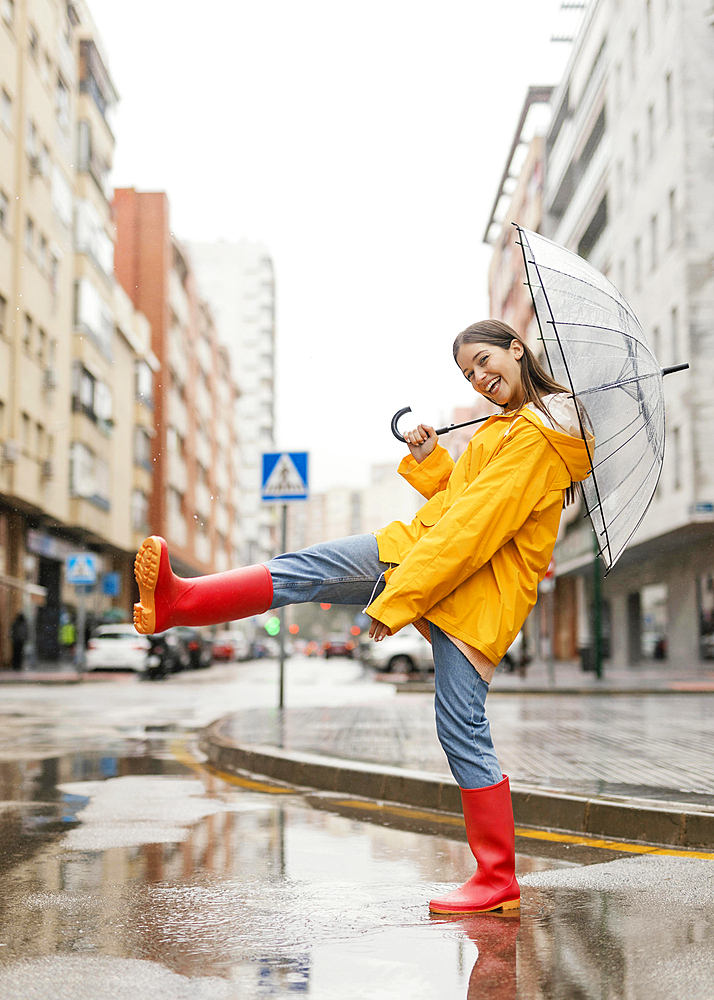 Woman with umbrella standing rain front view