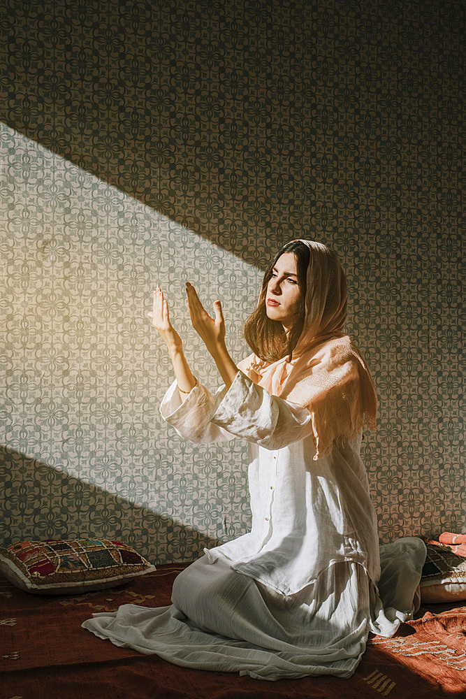 Muslim woman praying with sunlight effect