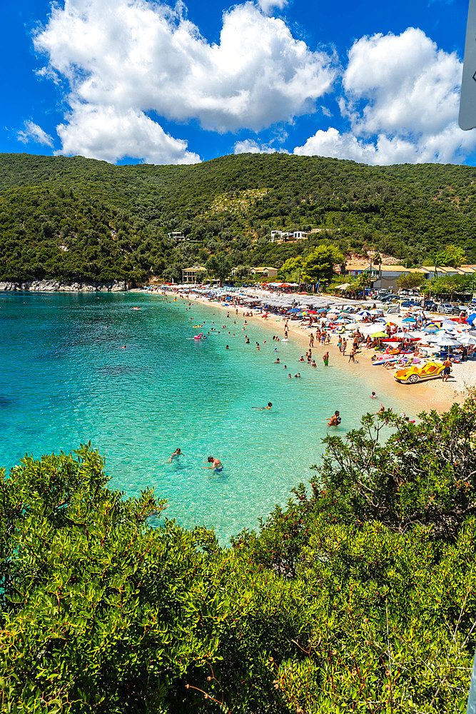 View of the beach in summer crowded with bather people at Paralia Mikros Gialos in Lefkada. Greece